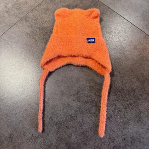 Detalle del gorro de punto naranja con orejas de gato y suave textura de mohair