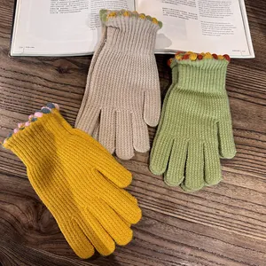 Detail of colorful wavy edges and warm knit texture on solid color winter gloves