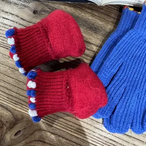 Winter knitted warm gloves and baby booties in red and blue with decorative poms