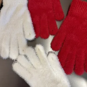 Close-up of the fluffy plush material and soft texture of red and white winter gloves