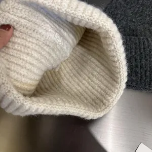 Detail of chunky knit winter hat interior showing rib pattern and care label