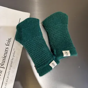 Dunkelgrüne Plüsch-Strickhandschuhe mit weißen Nähten und modischem Seitenlabel