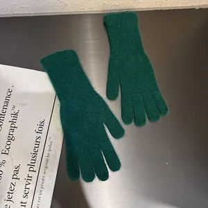 Detailansicht der dunkelgrünen Strickhandschuhe mit weicher Textur und gerippten Bündchen