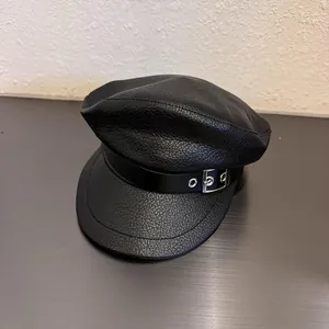 Close-up of black PU leather baker boy hat with lychee texture and silver metal buckle