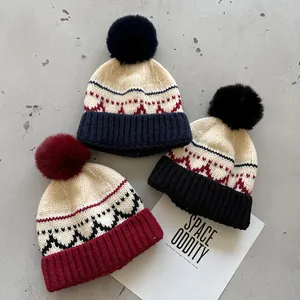 Platte weergave van gebreide mutsen met jacquardpatronen en faux fur pompons