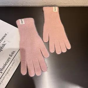 Detailaufnahme rosa Strickhandschuhe aus Kaninchenfell mit weicher Textur und Bund