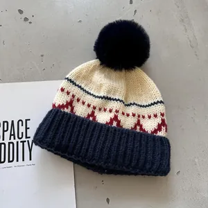Detail van de wintergebreide muts met witte wolstructuur en blauw geometrisch patroon