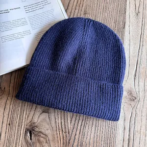 Dettaglio della trama a coste blu scuro e del risvolto ampio del berretto di maglia