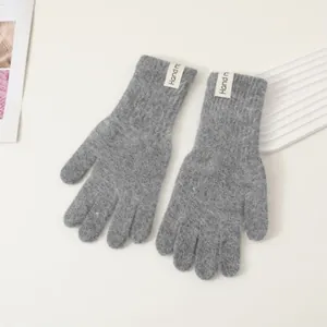 Detaillierte Textur grauer Strickhandschuhe mit dekorativem weißem Webetikett