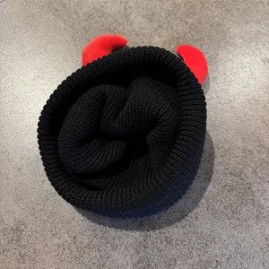 Berretto natalizio lavorato a maglia con corna rosse su cappello invernale a coste nero