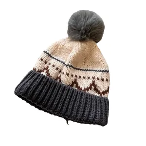 Winter gebreide muts met retro jacquardpatronen en een zachte pompon in beige en bruin