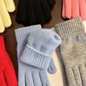 Nahaufnahme dicker Strickhandschuhe mit gerippten Bündchen in verschiedenen Farben
