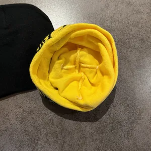 Knitted beanie hat in yellow and black featuring double-layer jacquard fabric and stitching