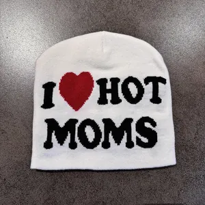 Detailed close-up of the knitted white beanie featuring 'I HOT MOMS' text and red heart