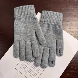 Detailansicht grauer Strickhandschuhe mit Fingeröffnungen für Touchscreen-Nutzung