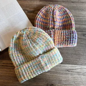 Detail of thick chunky knit beanies with gradient purple orange and mint colors