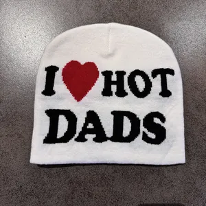 Close-up of white knitted beanie with black I Heart Dads text on grey background