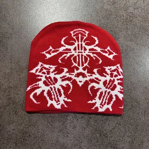 Close-up of red knitted beanie with white Gothic jacquard pattern and ethnic texture