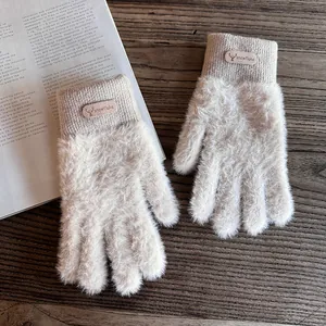 Detail von Plüsch-Strickhandschuhen mit Rentier-Lederpatch an gerippten Bündchen