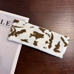 Detailed view of the cow print knitted headband showing soft fabric and jacquard texture