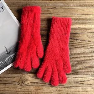 Detailansicht der roten Plüsch-Winterhandschuhe auf rustikalem Holz mit weicher Textur