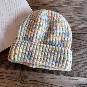 Detailed view of chunky mixed-color knit beanie texture in soft pastel rainbow tones