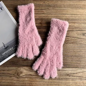 Detailansicht der flauschigen rosa Kunstpelz-Handschuhe auf einem rustikalen Holztisch