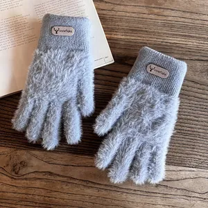 Detailansicht grauer Nerzimitat-Handschuhe mit warmem Fleecefutter und Hirschkopf-Lederpatch