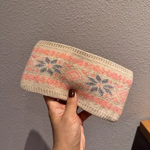 Gros plan du bandeau tricoté beige avec des motifs de flocon de neige jacquard