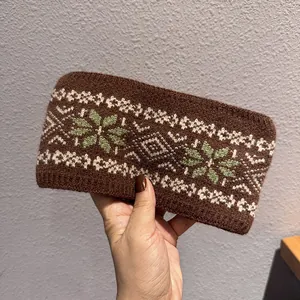 Détail du tissage du bandeau marron avec motifs jacquard de flocons blancs et verts
