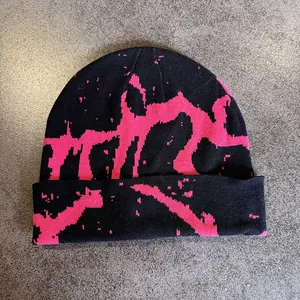 Detail of black knit beanie with vibrant pink abstract jacquard stripe pattern