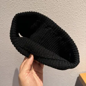 Knitted black winter headband for women with a minimalist elastic thick yarn design