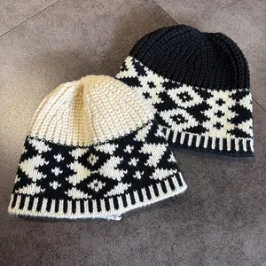 Detail of chunky knit beanies featuring ethnic jacquard patterns in black and beige colors