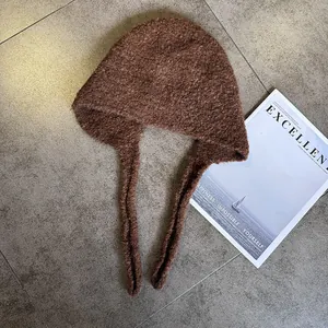 Detailed view of dark brown knitted balaclava with long straps and warm textured fleece