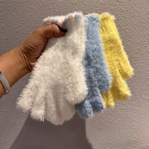 Dettaglio guanti invernali in peluche con texture soffice e polsini con motivo a pois