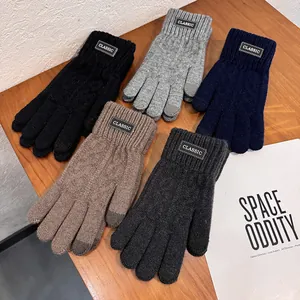 Close-up of knit winter gloves featuring touchscreen tips and classic leather label