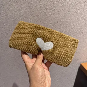 Close-up of mustard yellow knitted headband with white heart pattern and soft texture