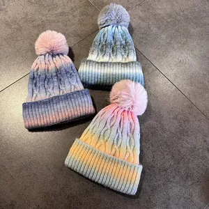 Trois bonnets en maille dégradée tie-dye avec pompons en fourrure et torsades