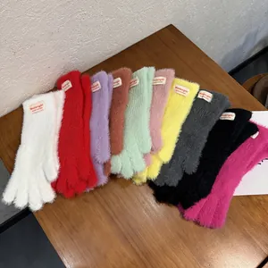 Guantes de felpa táctiles para invierno en diez colores sobre una mesa de madera