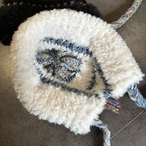 Detailed macro view of white plush earflap hat with colorful knitted stripe details