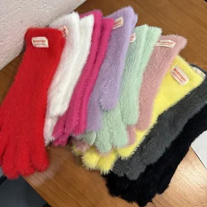 Guantes de invierno de felpa coloridos con función de pantalla táctil sobre fondo madera