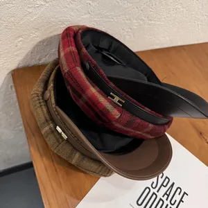 Vintage checkered baker boy hats in red and brown with wool texture and metal logo