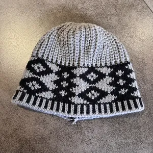 Close-up of retro knit jacquard beanie showing thick ribbed texture and geometric patterns