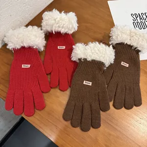 Detail of winter knitted touchscreen gloves with plush faux fur cuffs and brand label