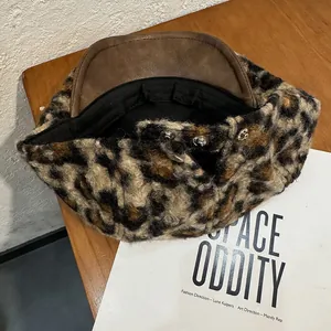 Détail d'un béret léopard en laine avec visière en cuir marron et bouton argenté