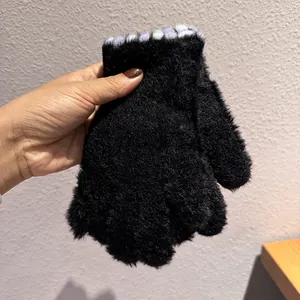 Dettaglio di muffole di peluche nero con accenti in maglia viola e bianchi sulle dita