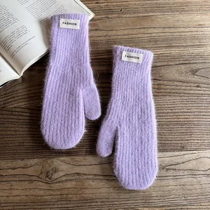 Detailed macro view of lavender faux fur mittens with a stylish white fashion label
