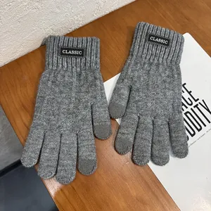 Close-up of grey knitted touchscreen gloves with CLASSIC label and ribbed cuffs