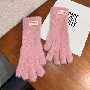 Primer plano de guantes de invierno de piel sintética rosa con textura suave y etiqueta