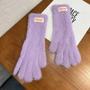 Detalle de guantes de punto afelpado morados con textura de piel sintética y etiqueta